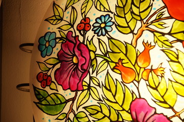 Colorful round hand-painted glass lamp with stained glass paints, with a floral pattern with leaves and flowers