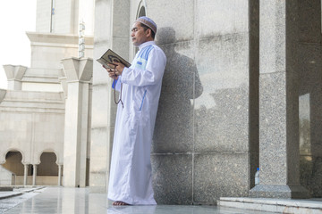 Middle age muslim man praying at mosque.