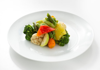 Boiled vegetables in a plate on a white background