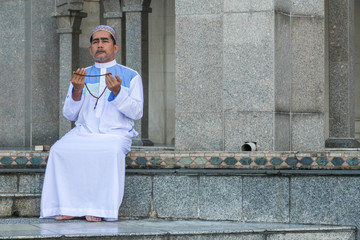 Middle age muslim man praying at mosque.