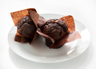 Chocolate muffin in a plate on a white background