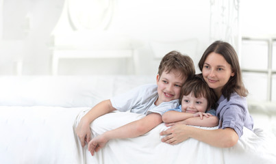 Obraz premium Happy parent and kids having fun sitting together on sofa,