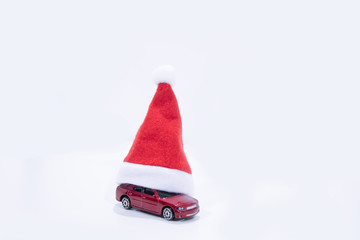 Christmas auto sale abstract photo. Red car under the New Year's hat