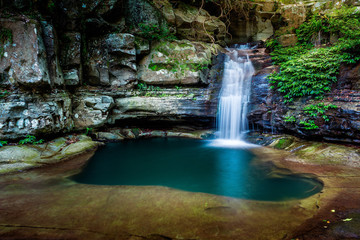 Fototapeta na wymiar Waterfall into a rock pool deep in the wilderness