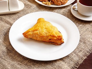 Samsa on a plate on a wooden table
