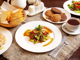 Dish of meat with vegetables on a plate on a wooden table