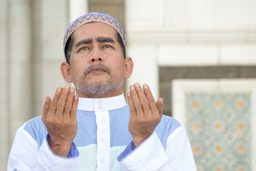 Middle age muslim man praying at mosque.