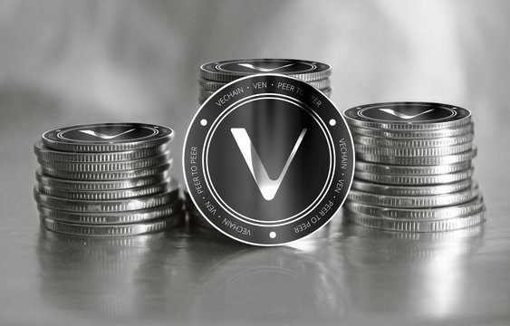 Vechain (VEN) digital crypto currency. Stack of black and silver coins. Cyber money.