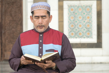 Middle age muslim man praying at mosque.
