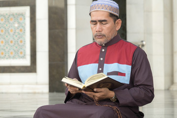 Middle age muslim man praying at mosque.