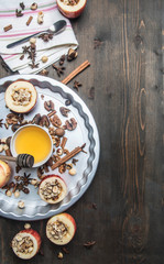 ingredients for cooking apples with honey and nuts, cinnamon and seasonings, sliced apples with filling on a rustic wooden background space for text