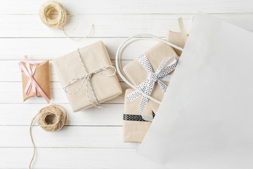 Gift boxes with decorations and paper bag on a white background, top view