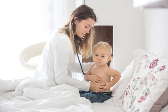 Young Doctor, Examiing Sick Baby Boy On A Home Visitation