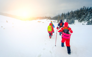 Hikers going towards old wood backcountry mountain huts covered with snow. Travel, lifestyle, active. adventure concept