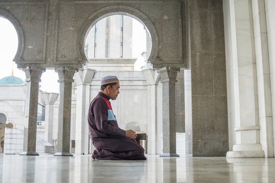 Middle age muslim man praying at mosque.