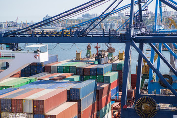 Container ship in port at container terminal view from crane. Ships of container ships stand in terminal of port on loading, unloading container.