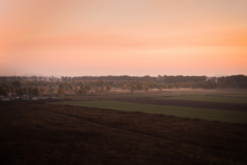 Fototapeta na wymiar Foggy pink sunset above the plains