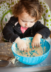 Little baby girl playing with dough