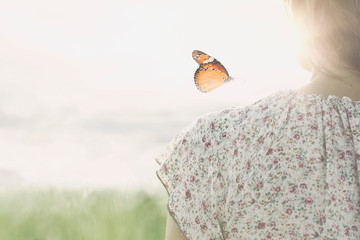 a colorful butterfly leans delicately on the shoulders of a girl