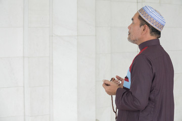 Middle age muslim man praying at mosque.