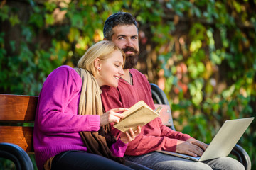 Man and woman use different information storage. Couple spend leisure reading. Couple with book and laptop search information. Information source concept. Share or exchange information knowledge