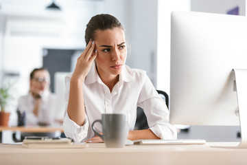 Business woman sitting in office working with computer.