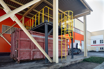 Fototapeta na wymiar At modern waste recycling plant, process of loading sorted garbage from conveyor belt into container for further transportation by truck recycling or disposal