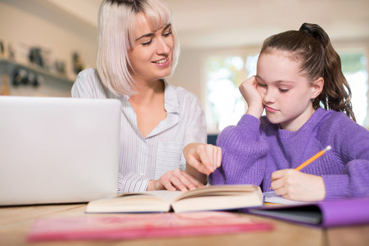 Female Home Tutor Helping Young Girl Struggling With Studies