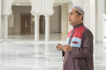 Middle age muslim man praying at mosque.