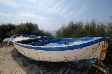 Puglia, Italy, August 2018, old wooden boat abandoned on the   shore of San Domino island