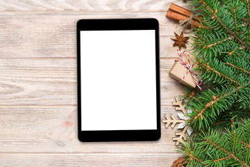 Digital tablet mock up with rustic Christmas wood background decorations for app presentation. top view with copy space