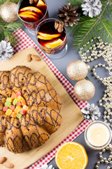 Christmas cake, two glasses of hot mulled wine with sliced orange. Christmas background with food and decorations.