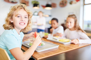 Obraz na płótnie Canvas Kinder essen in Kantine einer Grundschule Mittagessen