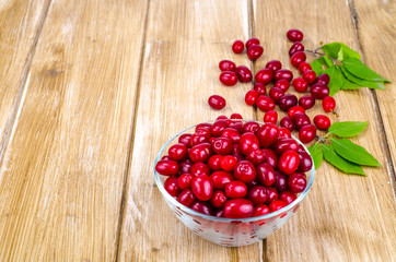Autumn ripe cornel berries on wooden table