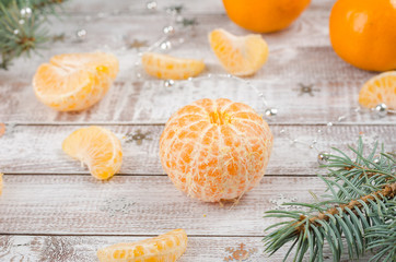 Peeled tangerines on wooden background