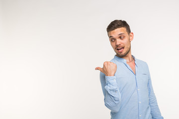 Advertisement and gesture concept - Successful man with smile on white background is pointing on empty copy space with his fingers