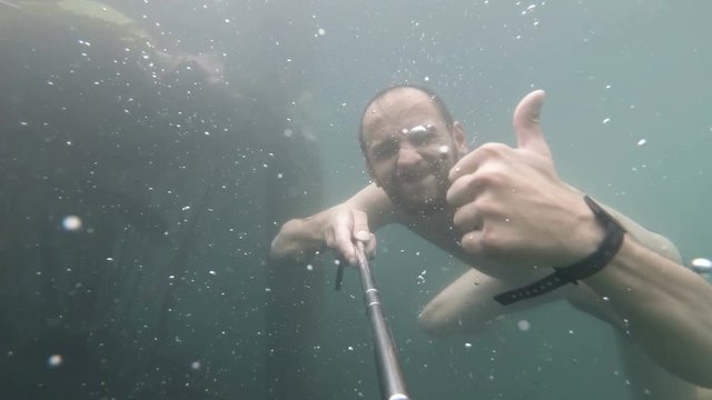 Underwater portrait of smiling man. Person having fun in swimming pool. Summer vacation concept. selphi.