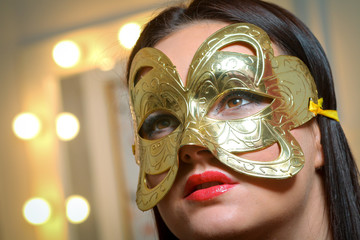 Beauty model woman wearing masquerade carnival mask over Christmas and New Year celebration holiday...