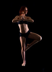 Redhead Girl doing yoga in studio