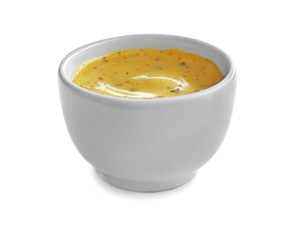Tasty yellow sauce in bowl on white background