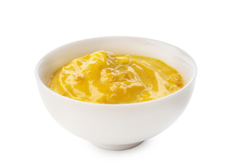 Tasty yellow sauce in bowl on white background