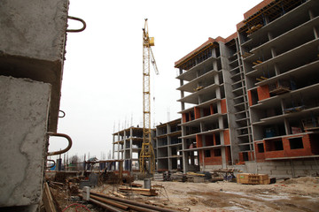 Construction of a residential multi-storey building. Working crane on the construction of the house