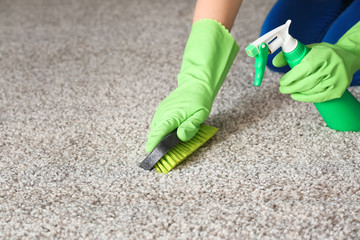 Woman cleaning carpet at home