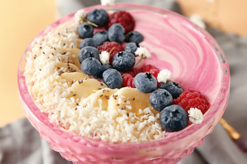 Glass bowl with pink yogurt and fresh fruits, closeup