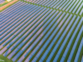 Aerial drone view of solar panels at a solar energy generation farm at Sunset in South Wales, UK