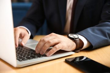 Young businessman working with laptop, closeup