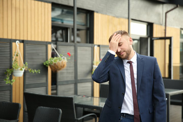 Emotional young businessman after making mistake outdoors