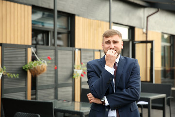 Emotional young businessman after making mistake outdoors