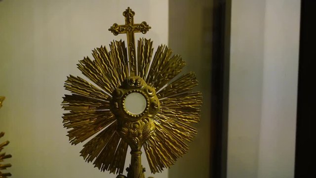 A steady, medium shot of two golden metal sun monstrances at the exhibition in a museum.