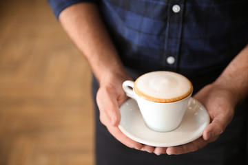 Man holding cup of aromatic coffee, closeup